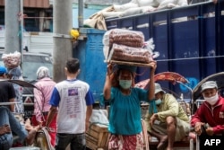 Seorang buruh panggul perempuan sedang bekerja di sebuah pasar di Surabaya, 8 Maret 2021. Setelah 19 tahun pemberlakukan Undang-Undang Penghapusan Kekerasan dalam rumah tangga (KDRT), angka kasus KDRT tetap tinggi. (Foto: Juni Kriswanto/AFP)