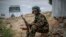 FILE - A fighter loyal to the Tigray People's Liberation Front (TPLF) mans a guard post on the outskirts of the town of Hawzen, May 7, 2021.