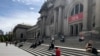 Virus Outbreak New YorOrang-orang duduk di luar Metropolitan Museum of Art pada Sabtu, 2 Mei 2020 di New York. (Foto: AP)