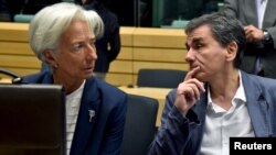 Direktur IMF Christine Lagarde (kiri) berbicara dengan Menteri Keuangan Yunani Euclid Tsakalotos dalam pertemuan menteri-menteri keuangan zona euro tentang situasi Yunani di Brussels, Belgia, 12 Juli 2015.