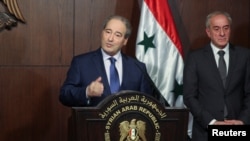 فەیسەڵ مەقداد وەزیری دەرەوەی سوریا لە میانی کۆنگرەیەکی ڕۆژنامەوانی لە دیمەشق قسە دەکات