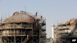 Para pekerja memperbaiki kerusakan di pemisah minyak Aramco di fasilitas pemrosesan setelah serangan 14 September baru-baru ini di Abqaiq, dekat Dammam di Provinsi Timur Kerajaan, Jumat, 20 September 2019. (Foto: AP/Amr Nabil)