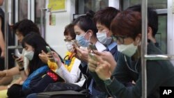 Para penumpang kereta api bawah tanah di Seoul. 