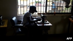 FILE - A victim of human trafficking in Libya sews clothes in Benin, Edo State, Nigeria, Oct. 21, 2016. Human Rights Watch says in a new report that Nigerian trafficking survivors are not getting enough support from their government.