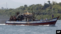 Filipino fishermen wave from a fishing boat bound to fish near Scarborough Shoal in Masinloc, Zambales May 10, 2012. 