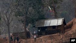 FILE - In this March 30, 2021, photo, Myanmar soldiers stand at a small army camp along the river bank near the border of Myanmar and Thailand. Ethnic Karen guerrillas said they captured the Myanmar army base Tuesday, April 27, 2021.