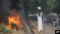 A Sudanese protester stands on a barricade during a demonstration in Khartoum, September 14, 2012, as part of widespread anger across the Muslim world about a film ridiculing Islam's Prophet Muhammad. 