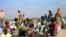 FILE - Somali refugees wait for a plane to take them home from Dabaab refugee camp in northern Kenya.