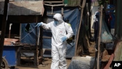 A member of the non-profit Cambodian Children's Fund sprays disinfectant to help curb the spread of the new coronavirus in southern Phnom Penh, Cambodia, where some people are detained for sharing information about the coronavirus.