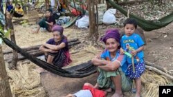 In this photo released by the Free Burma Rangers, ethnic Karen women sit with family members in the jungles of northern Karen State where they are sheltering from an ongoing local offensive by the Myanmar army, on Jan. 27. (Free Burma Rangers via AP)