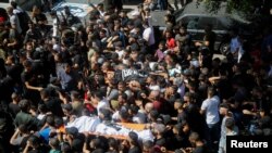 Ribuan warga menghadiri upacara pemakaman dua laki-laki Palestina yang dibunuh tentara Israel di Nablus, Tepi Barat hari Minggu (24/7). 