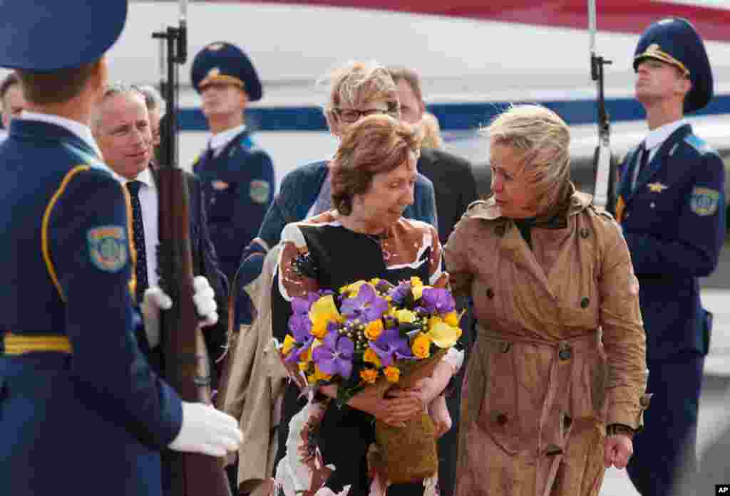 European Union High Representative for Foreign Affairs and Security Policy Catherine Ashton, center, is given flowers upon her arrival in Minsk, Belarus, Aug. 26, 2014.