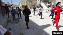 People run for cover after what activists said was shelling by forces loyal to Syria's President Bashar al-Assad in Raqqa province, eastern Syria, June 10, 2013. 