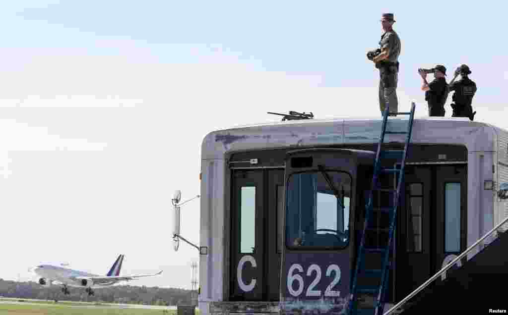Security personnel watch as the airplane carrying French President Francois Hollande and his companion Valerie Trierweiler arrives for the G-8 Summit at Dulles International Airport in Chantilly May 18, 2012.