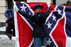 FILE - Mississippi Highway Safety Patrol honor guard folds the retired Mississippi state flag after it was raised over the Capitol grounds one final time in Jackson, Mississippi, July 1, 2020.