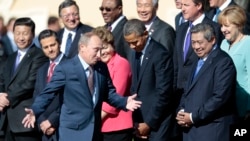 President Rusia Vladimir Putin, lewat di depan Presiden AS Obama, saat mengambil posisi untuk pengambilan foto bersama para kepala negara di Istana Konstantin, St. Petersburg, Rusia (6/9).
