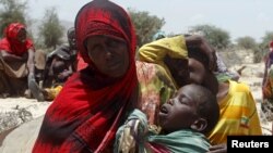 A displaced woman and her children wait for assistance at Habaas town of Awdal region, Somaliland April 9, 2016.