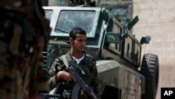 Seorang tentara Yaman tengah berjaga di sebuah pos penjagaan di jalanan menuju Kedutaan AS dan Inggris di Sanaa, Yaman, 10 Agustus 2013 (Foto: dok). Tersangka militan al-Qaida dilaporkan melancarkan tiga serangan serentak di selatan Yaman, menewaskan 56 polisi dan tentara, Jumat (20/9).