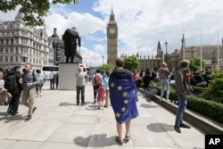 Wrapped in an EU flag, a demonstrator protests Britain's exit from the European Union at a rally in Parliament Square, London, June 25, 2016.