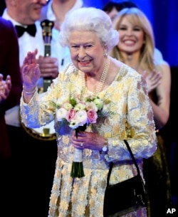 Queen Elizabeth II waves from the stage at the Royal Albert Hall in London, April 21, 2018, for a concert to celebrate her 92nd birthday.