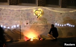 A man reads messages of condolence on a wall near a tower block severely damaged by a serious fire, in north Kensington, West London, June 15, 2017.