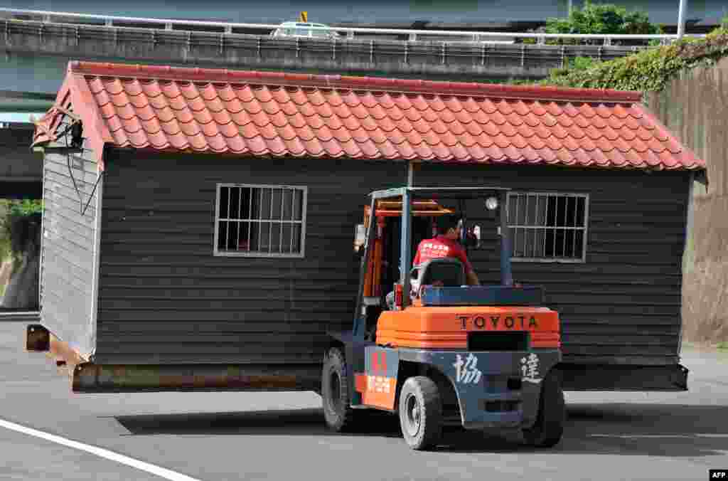 Pegawai pemerintah kota Taipei memindahkan sebuah rumah dari pinggiran Sungai Yanping yang diperkirakan akan dilanda banjir akibat badai yang akan melanda Taiwan.
