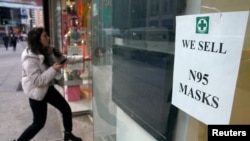 A woman walks into a pharmacy to purchase N95 face masks in advance of the potential coronavirus outbreak in the Manhattan borough of New York City, New York, Feb. 27, 2020. 