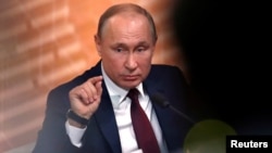 FILE - Russian President Vladimir Putin gestures during his annual end-of-year news conference in Moscow, Dec. 19, 2019.