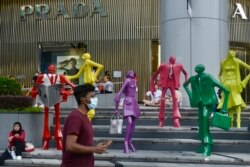Orang-orang yang memakai masker berjalan di sepanjang area perbelanjaan Orchard Road di Singapura pada 28 November 2021. (Foto: AP)