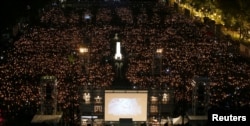FILE - Thousands of people take part in a candlelight vigil to mark the 29th anniversary of the crackdown of pro-democracy movement at Beijing's Tiananmen Square in 1989, at Victoria Park in Hong Kong, China, June 4, 2018.