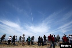 FILE - People watch as the Ground-based Midcourse Defense (GMD) element of the U.S. ballistic missile defense system launches during a flight test from Vandenberg Air Force Base, Calif., May 30, 2017.
