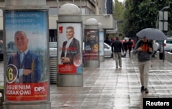 A man walks past election posters ahead of the parliamentary elections in Podgorica, Montenegro, Oct. 6, 2016.