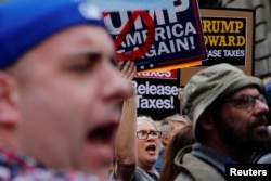 Demonstrators march past Trump Tower as they protest through Manhattan demanding U.S. President Donald Trump release his tax returns, in New York, April 15, 2017.