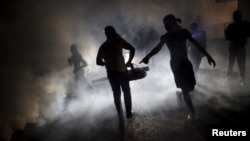 FILE - A worker of the Ministry of Public Health and Population fumigates in the street against mosquito breeding to prevent diseases such as malaria, dengue and Zika in Port-au-Prince, Haiti, Feb. 15, 2016.