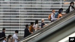 People wearing face masks to help protect against the spread of the coronavirus ride an escalator as they arrive at the Seoul Railway Station in Seoul, South Korea, Monday, Aug. 24, 2020.South Korea counted its 11th straight day of triple-digit…