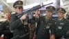 Chinese officers check rifles of ARES Defense Systems, Inc from the U.S. at the Special Operations Forces Exhibition and Conference (SOFEX) at King Abdullah I Airbase in Amman, Jordan, May 8, 2012. 