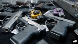 FILE - Handguns are displayed on a vendor's table at an annual gun show in Albany, N.Y., Jan. 26, 2013.