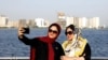 FILE - Iranians take a selfie at the Persian Gulf Martyrs lake, west of Tehran, July 7, 2019. Some daring women in Iran's capital have been taking off their mandatory headscarves, or hijabs, in public, risking arrest.