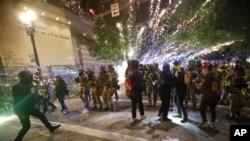 Federal officers advance on demonstrators during a racial justice protest at the Mark O. Hatfield United States Courthouse July 25, 2020, in Portland, Ore. 