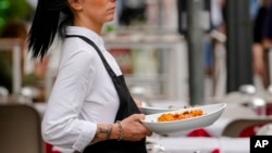 ພະນັກງານເສີບອາຫານຢູ່ຮ້ານອາຫານແຫ່ງນຶ່ງ.