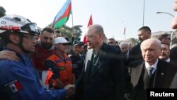 Presiden Turki Tayyip Erdogan, didampingi Devlet Bahceli, pemimpin Partai Gerakan Nasionalis (MHP), bertemu dengan anggota tim penyelamat Meksiko di Antakya di Provinsi Hatay, Turki, 20 Februari 2023. (Foto: via REUTERS)