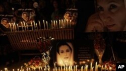 Posters of Pakistan's slain leader Benazir Bhutto and candles are held by her supporters at a ceremony to mark the third anniversary of her death, in Islamabad, Pakistan, 27 Dec 2010.