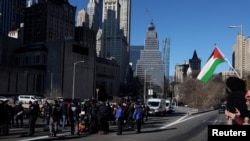 Pro-Palestinian demonstrators are taken into custody by the NYPD after blocking a Brooklyn Bridge roadway during a 'Shut it Down for Palestine' protest in New York City