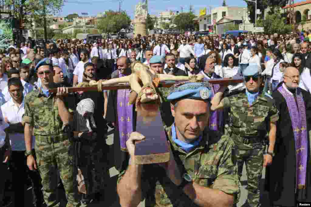Serbian and Spanish U.N. peacekeepers carry a cross with a statue of Jesus Christ during a Good Friday ceremony in Kalayaa, Marjayoun countryside in south Lebanon, April 18, 2014.&nbsp;