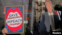 지난 1월 미국 보스턴에서 열린 여성 권익 행사장에서 도널드 트럼프 대통령의 탄핵 지지자와 반대자가 각가 관련 포스터를 들고 있다.