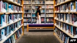 香港一些泛民主派人士撰写的书籍近日遭政府公共图书馆下架。一位女士2020年7月4日在香港一家公共图书馆内。