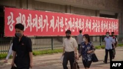 19일 북한 평양에 당 제8차대회가 제시한 과업을 관철하자는 내용의 구호가 걸려있다.