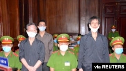 Freelance journalists of the Independent Journalists Association of Vietnam Pham Chi Dung, right, Le Huu Minh Tuan, center, and Nguyen Tuong Thuy stand during their trial Jan. 5, 2021.