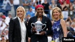 Serena Williams holds her trophy while flanked by tennis greats Martina Navratilova (L) and Chris Evert following the women's singles finals match at the 2014 U.S. Open tennis tournament in New York, September 7, 2014.