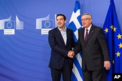 FILE - European Commission President Jean-Claude Juncker, right, welcomes Greece's PM Alexis Tsipras upon his arrival at the European Commission headquarters in Brussels, Feb. 4, 2015.